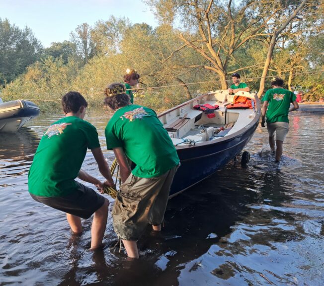 Students from The King Alfred School Sixth Form pull a rowing boat through the water towards the banks of the River Thames