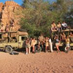 Students from The King Alfred School pictured in front of two trucks, some sitting on the roof and some standing