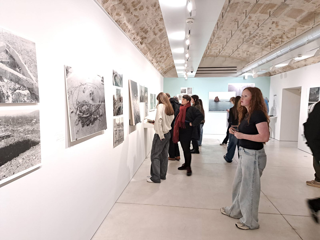 Sixth Form students from The King Alfred School look at photographs in an exhibition space