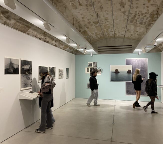 Sixth Form students from The King Alfred School look at photographs in an exhibition space