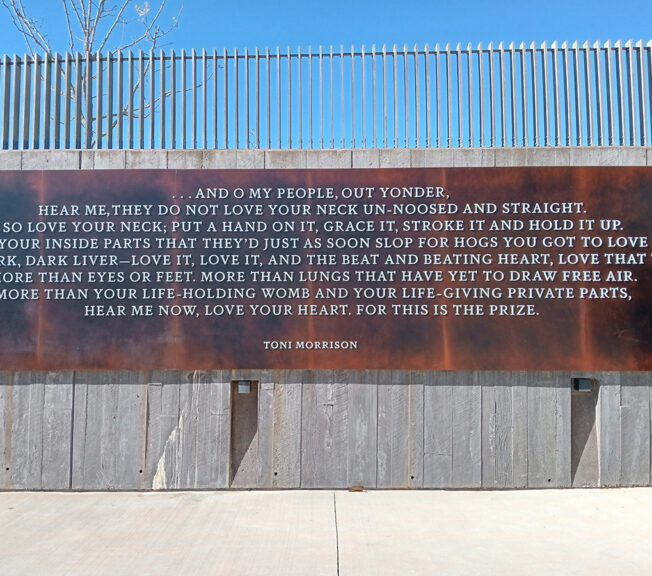 A steel plaque engraved with the words of Toni Morrison, which reads: “And O my people, out yonder, hear me, they do not love your neck unnoosed and straight. So love your neck; put a hand on it, grace it, stroke it and hold it up. And all your inside parts that they’d just as soon slop for hogs, you got to love them. The dark, dark liver—love it, love it, and the beat and beating heart, love that too. More than eyes or feet. More than lungs that have yet to draw free air. More than your life-holding womb and your life-giving private parts, hear me now, love your heart. For this is the prize.