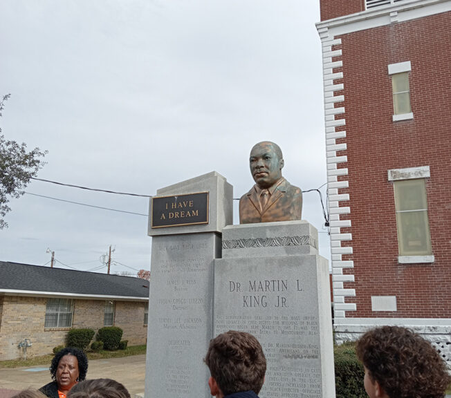 Students look at a bust of Martin Luther King outside a building in Selma, Alabama