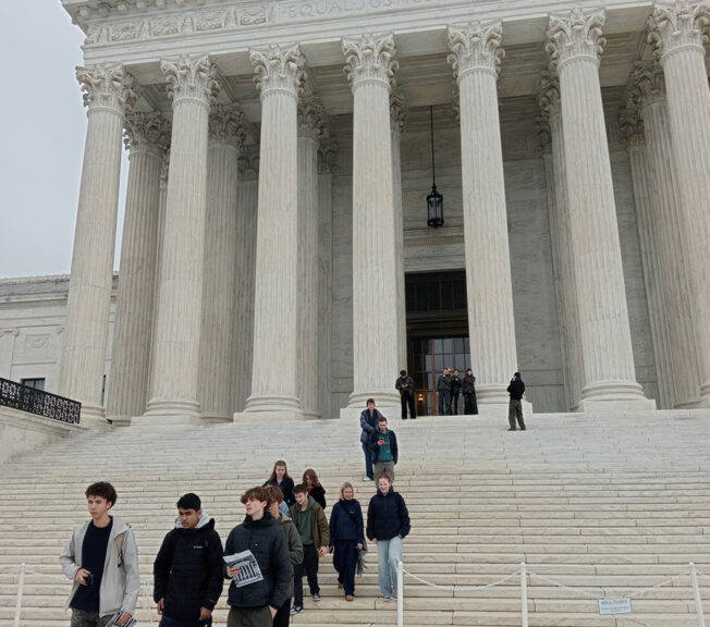 Students from The King Alfred School walk down the white steps of the Supreme Court of the United States