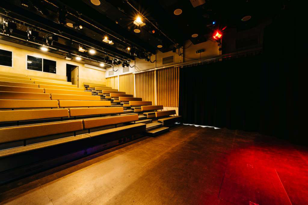 The King Alfred Phoenix Theatre with bench style seating in place and the stage lit up