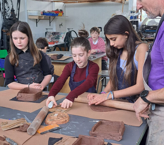 Students in the art room creating clay moulds at The King Alfred School North London