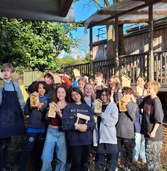 A group of students at The King Alfred School North London holding up bird feeders they have made in the Design Technology department