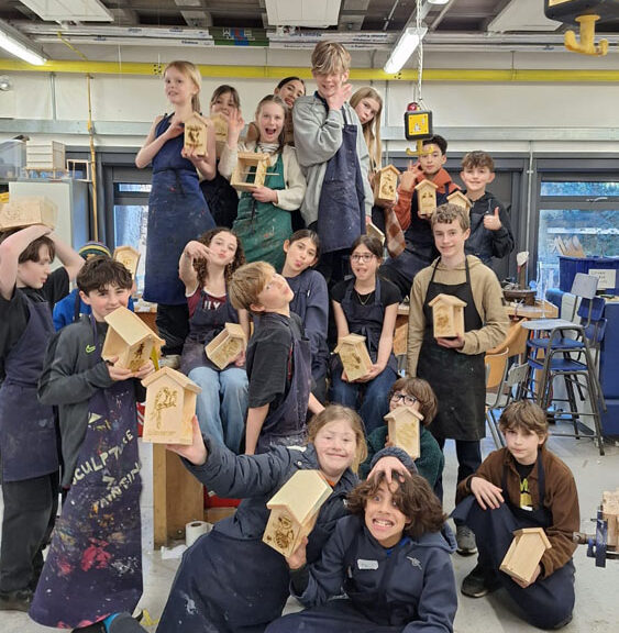 A group of students at The King Alfred School North London holding up bird feeders they have made in the Design Technology department