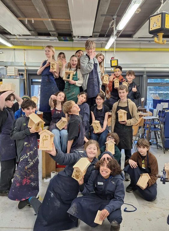 A group of students at The King Alfred School North London holding up bird feeders they have made in the Design Technology department