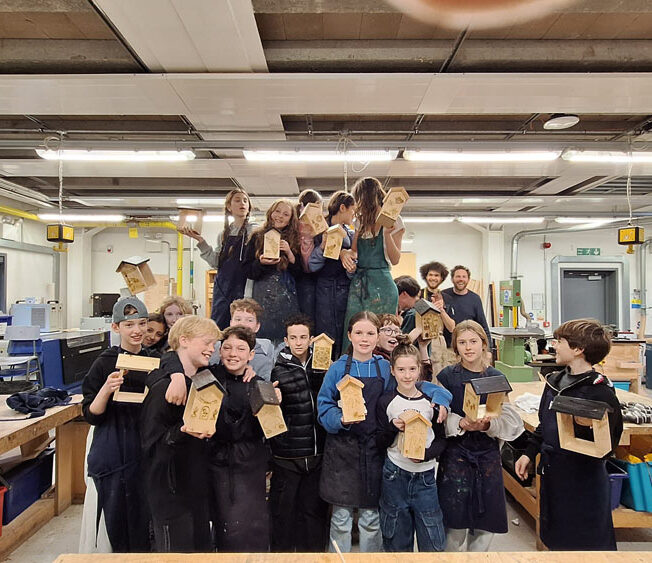 A group of students at The King Alfred School North London holding up bird feeders they have made in the Design Technology department