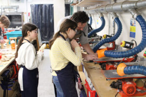 A staff member shows a student how to use the jigsaw